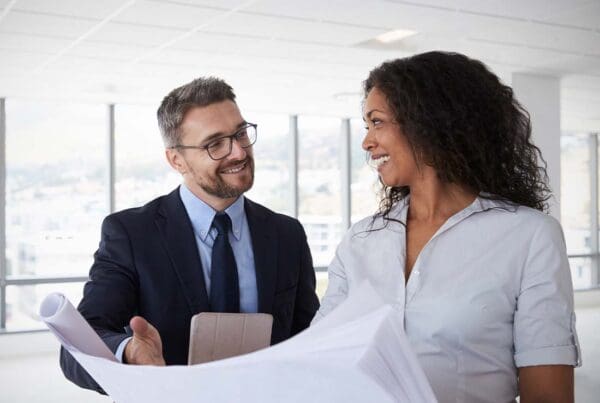 Real Estate Developer Insurance - Real Estate Developers Meeting in an Empty Office of a Tall Corporate Building to Look Over Development Plans