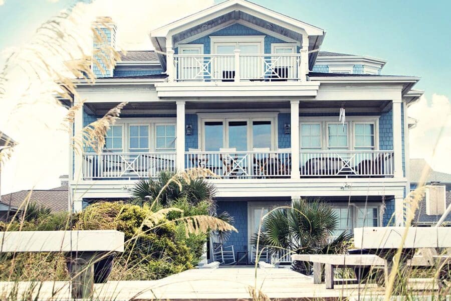 Secondary Home Insurance - Luxury Beach Front Vacation Home with Multiple Balconies and Private Dock in the Summer at Dusk