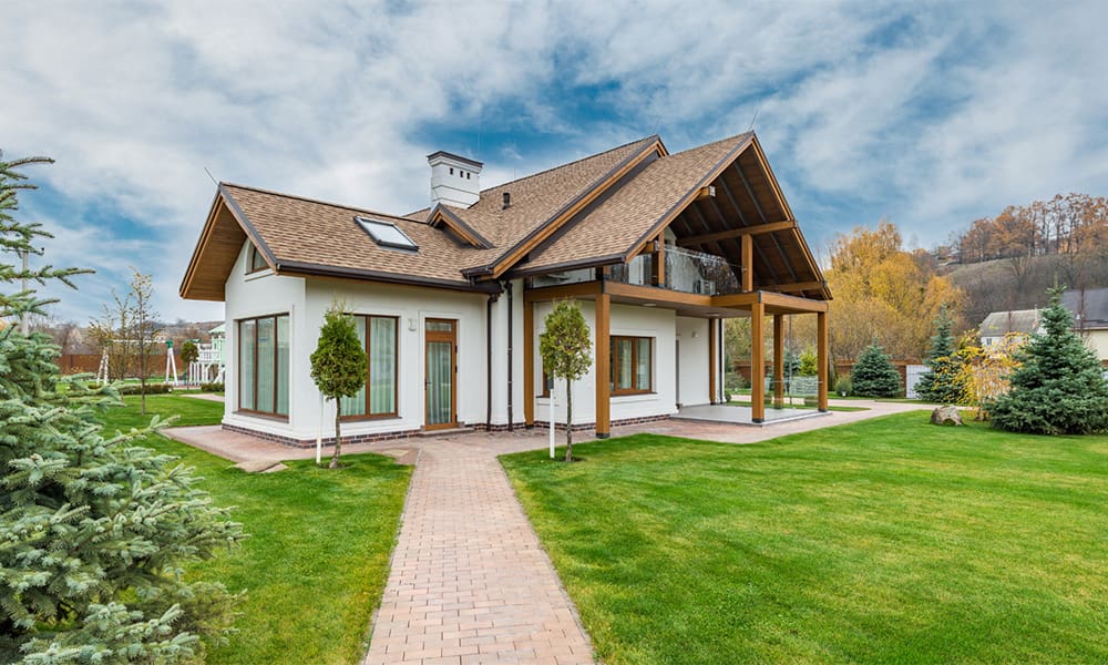 Homeowners Insurance 101 Protect Your Home - Home on Cloudy Day With Brick Path Across Green Lawn