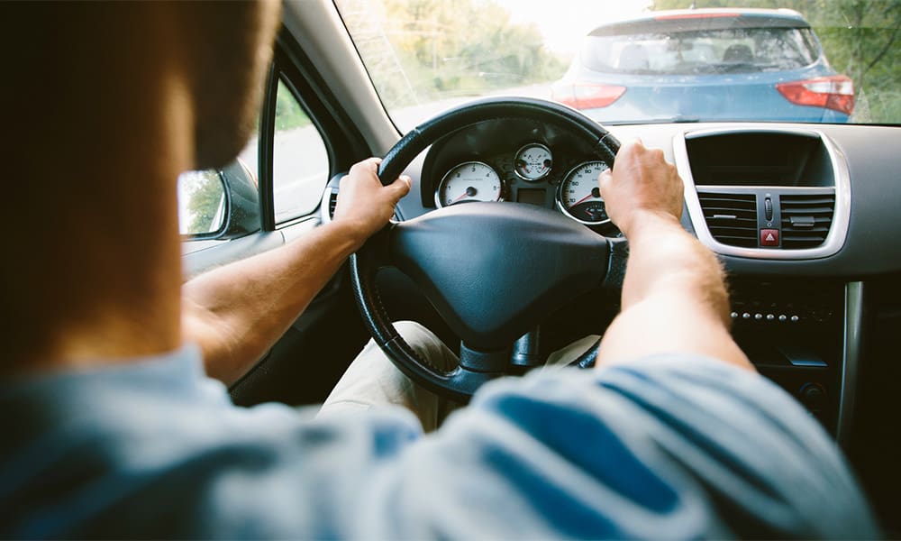 Rising Auto Insurance Rates in 2025- Causes and Solutions - Driving on Sunny Day Focus on Steering Wheel